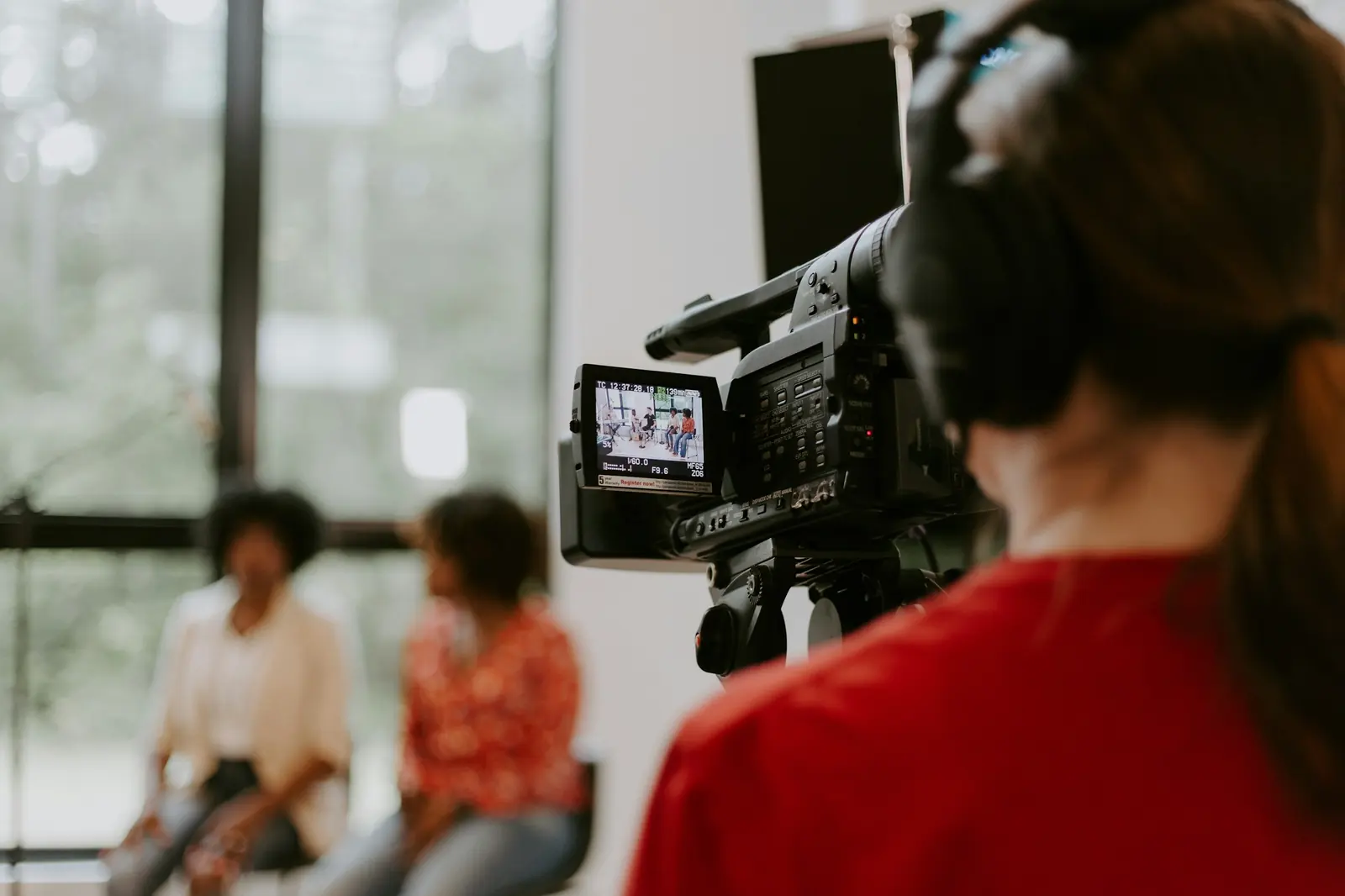 A camera operator filming a two-person interview