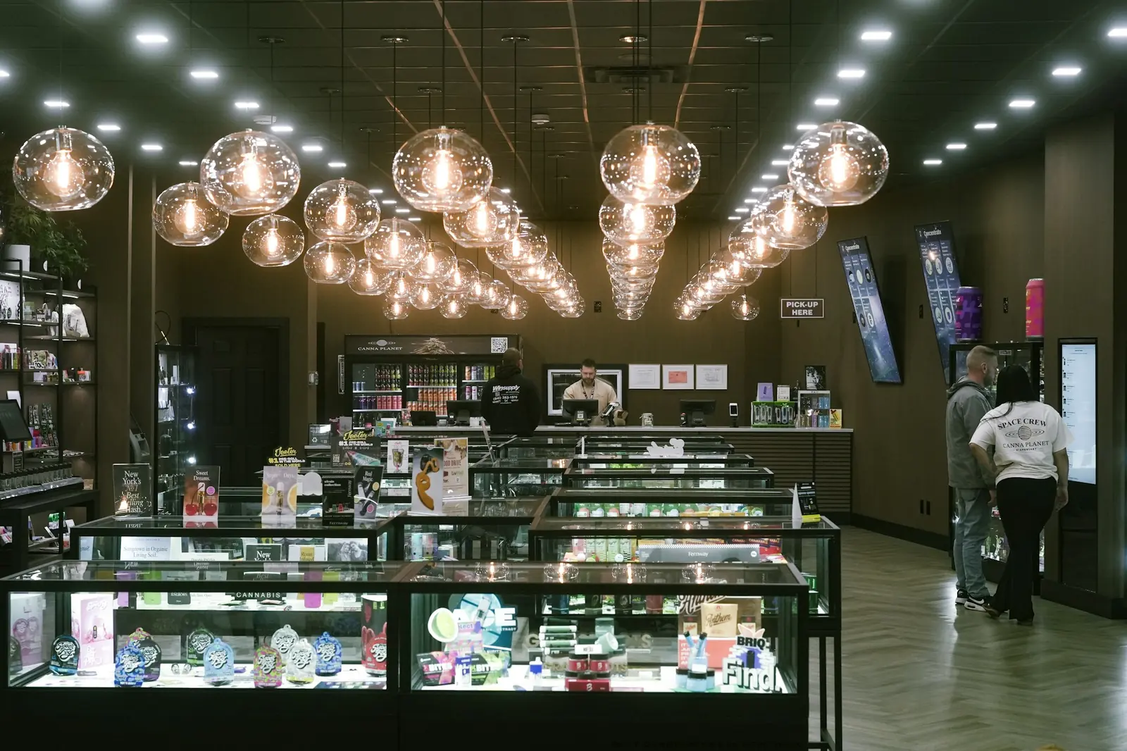 A store floor with glass display cases under pendant lights