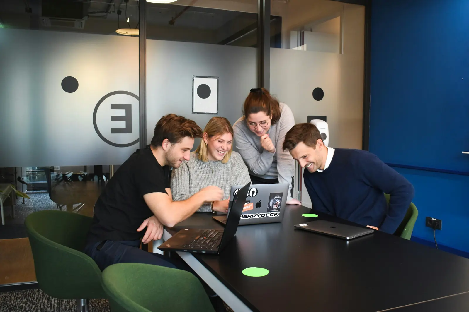 A team gathered around one laptop